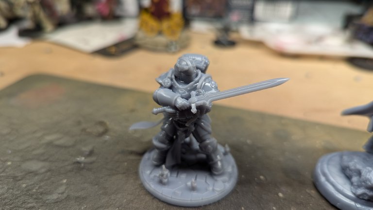 A 3D-printed resin miniature on a workbench.