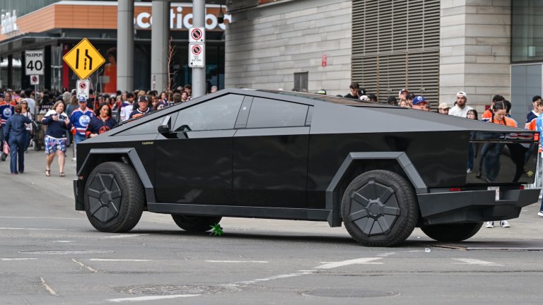 black cybertruck in front of a crowd