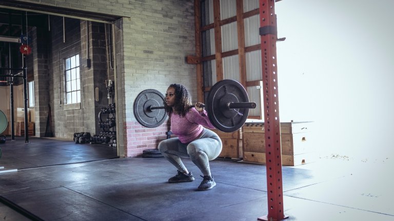 Young woman lifting weights at gym