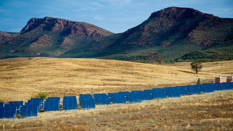Solar panel station in Australian outback in front of mountains